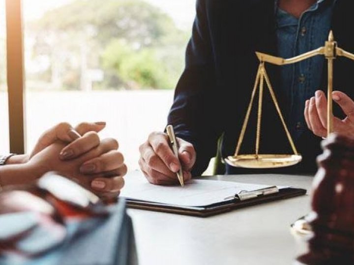 Arquitecto revisando documentos legales y planos con cliente en oficina